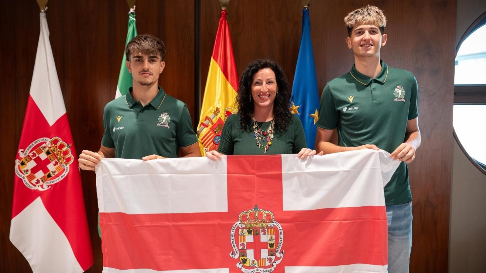 Mario García, María del Mar Vázquez y José Joaquín Cañadas posan con la bandera de la ciudad.