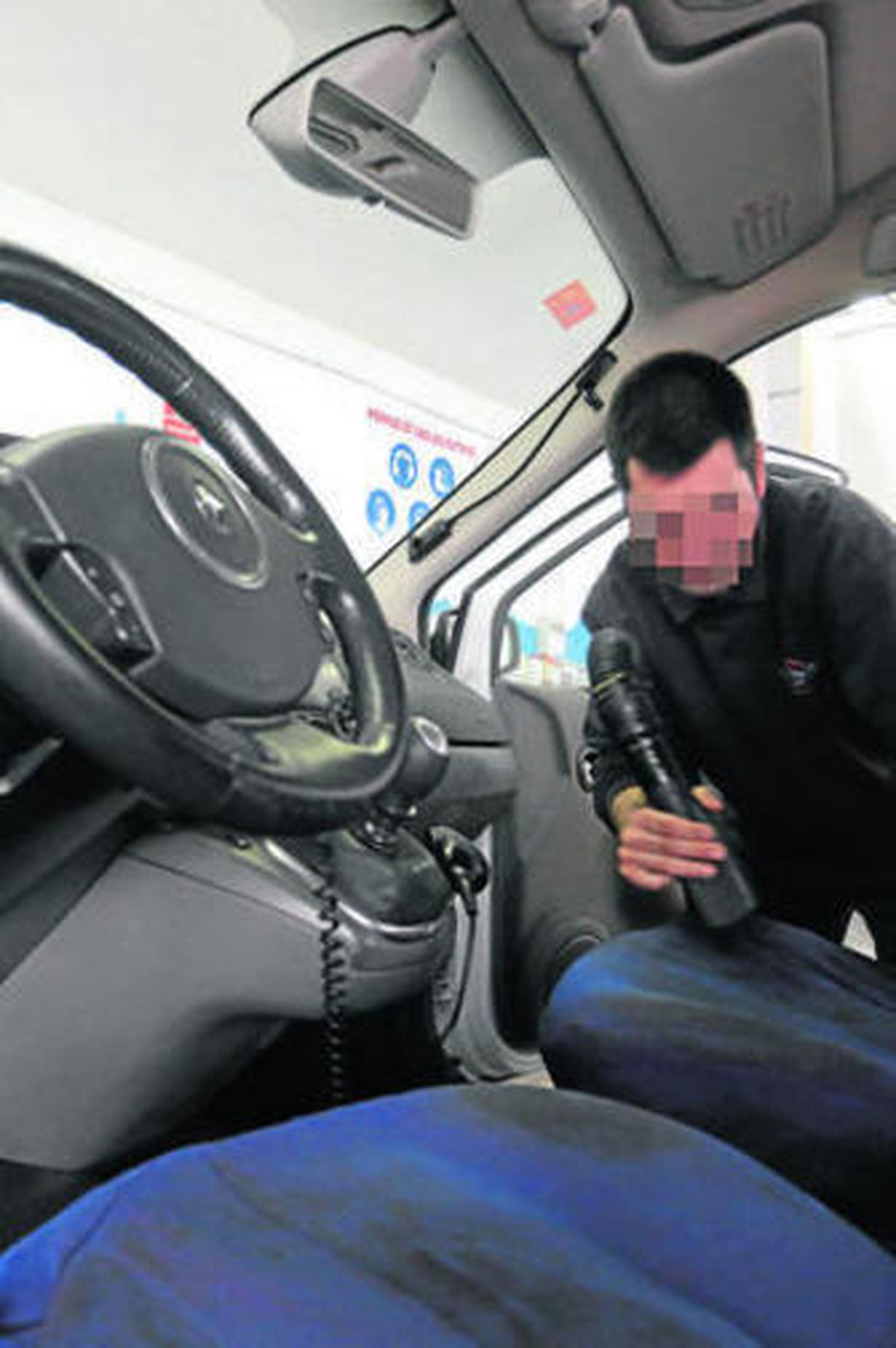 Un joven empleado de un centro especial de empleo limpia un coche.