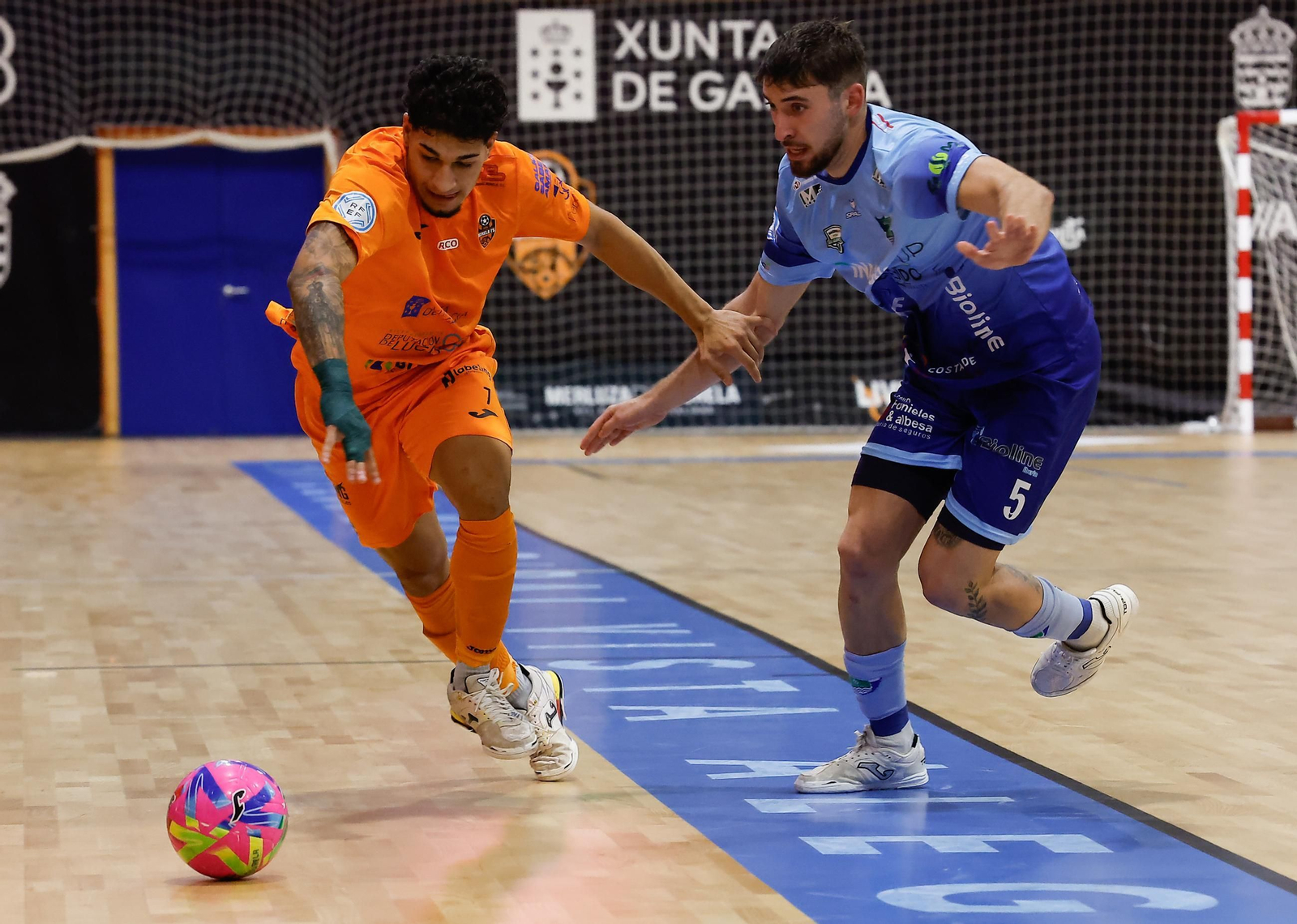 El celeste Adri Blat persigue a un rival que se marcha en carrera durante el encuentro disputado en Burela.