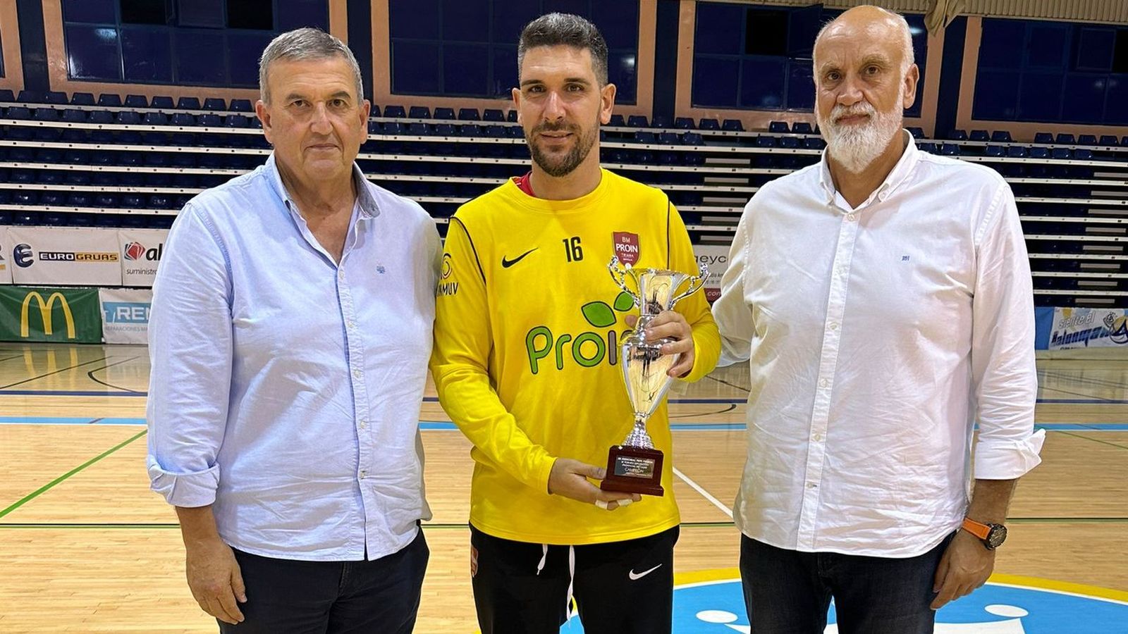 Jorge Oliva, capitán del BM Triana, con el trofeo, entre Pedro Soria y Javier Vidal