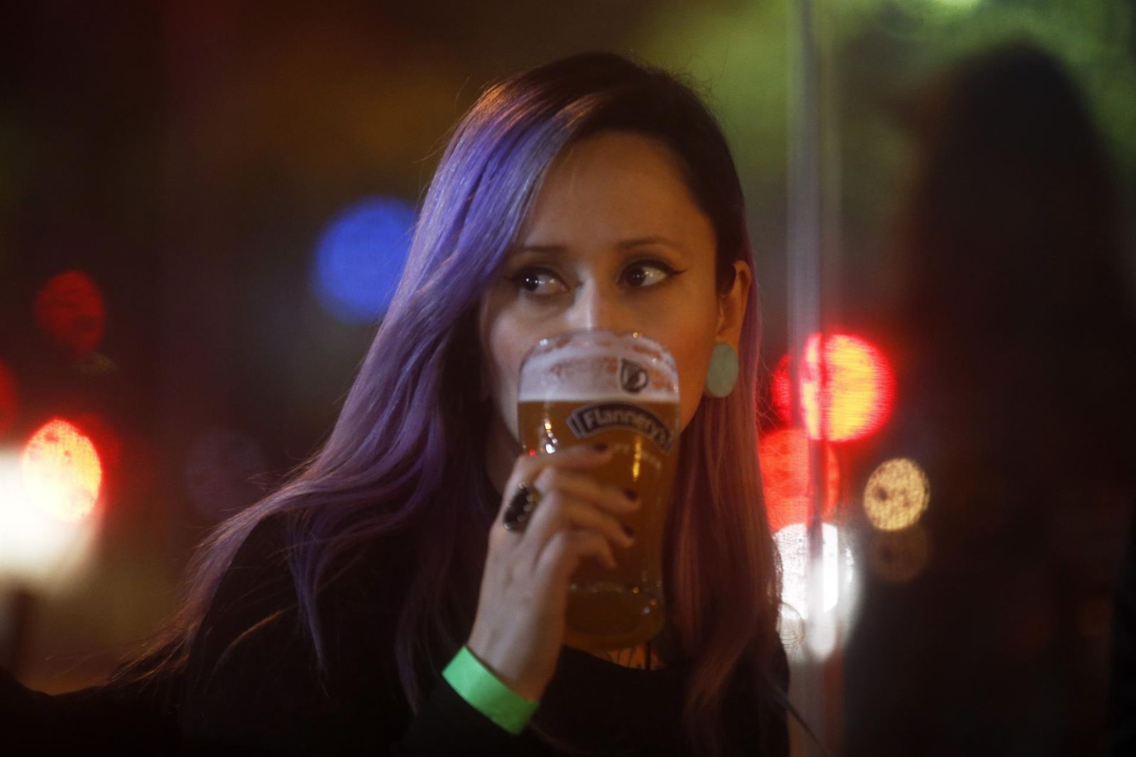 Una mujer bebe una cerveza