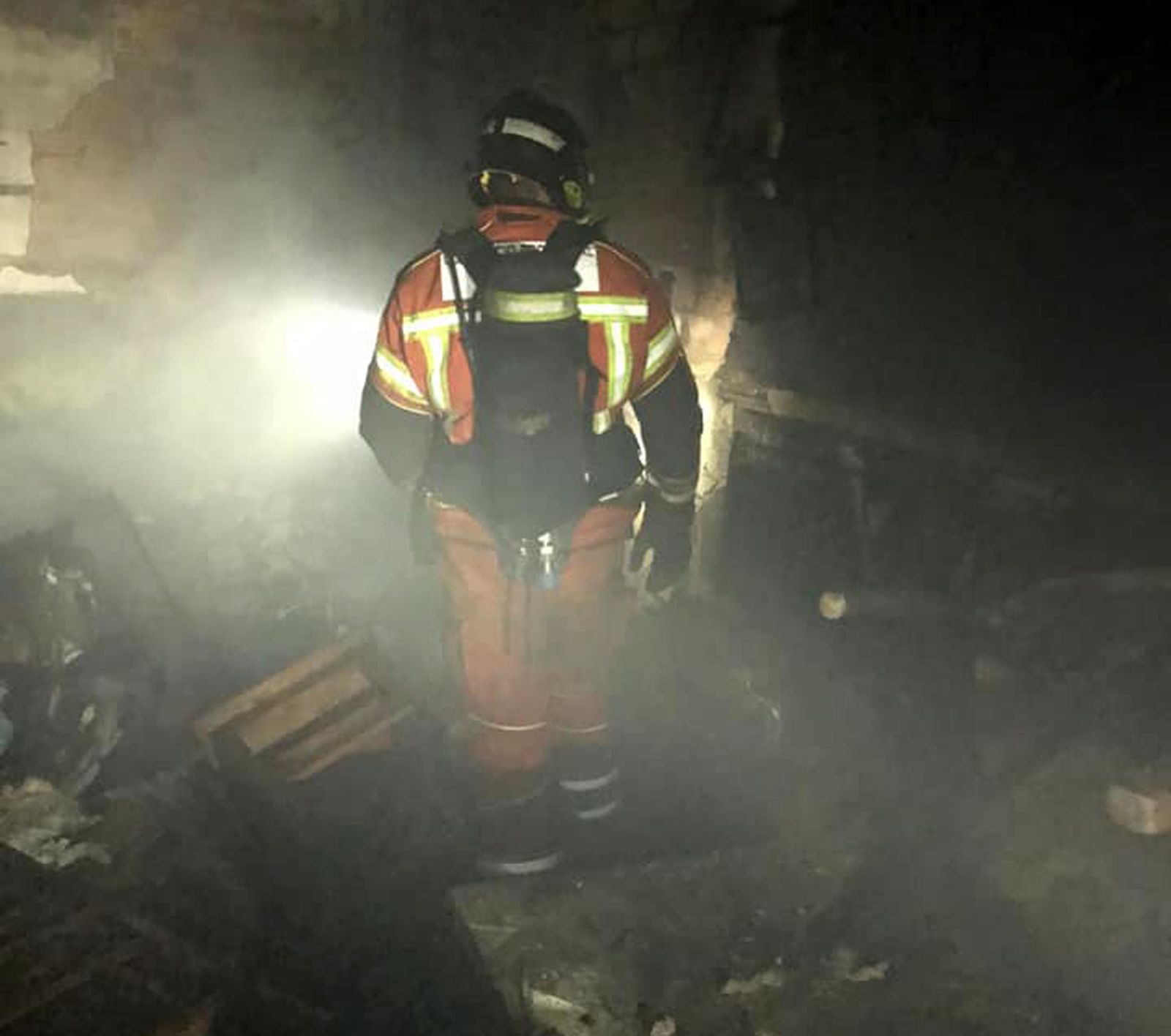 Uno de los bomberos revisa los daños producidos por el fuego