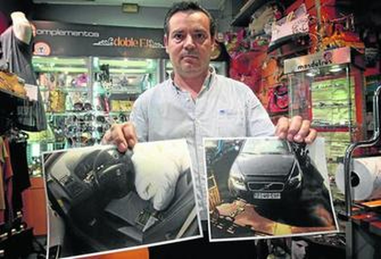 Juan Ortega muestra las fotografías que su amigo le hizo a su coche en el desguace donde lo encontró, ayer en la papelería que regenta en Triana.
