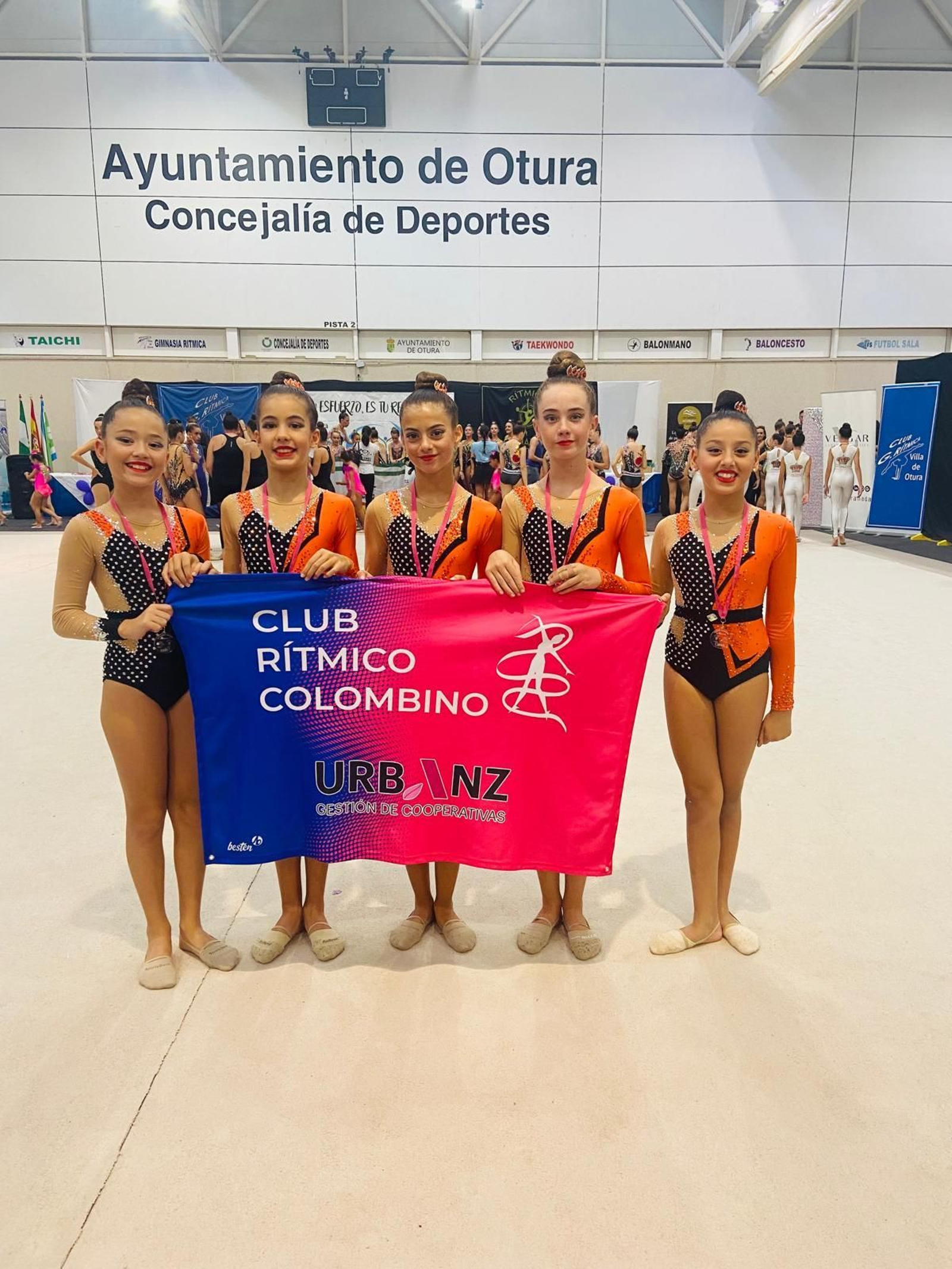 Gimnastas portan una bandera del Rítmico Colombino.