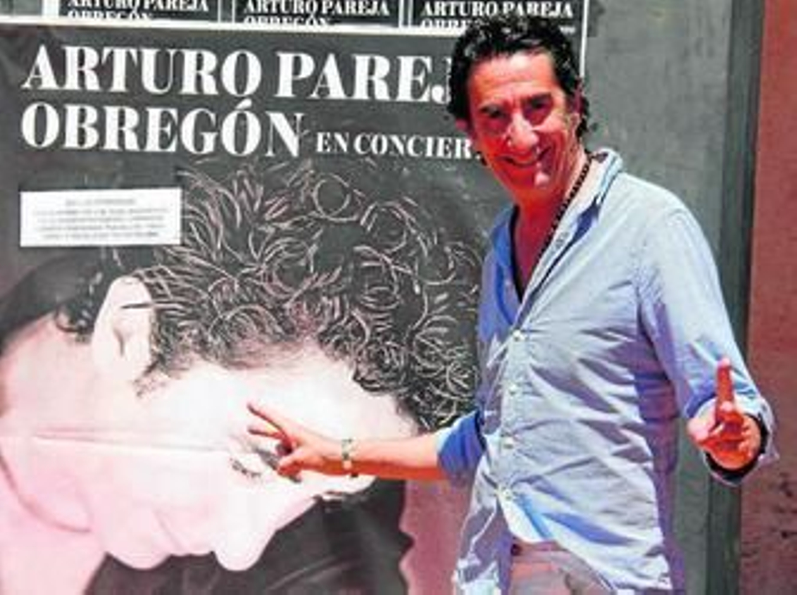 Pareja Obregón posa delante del cartel promocional de su concierto.