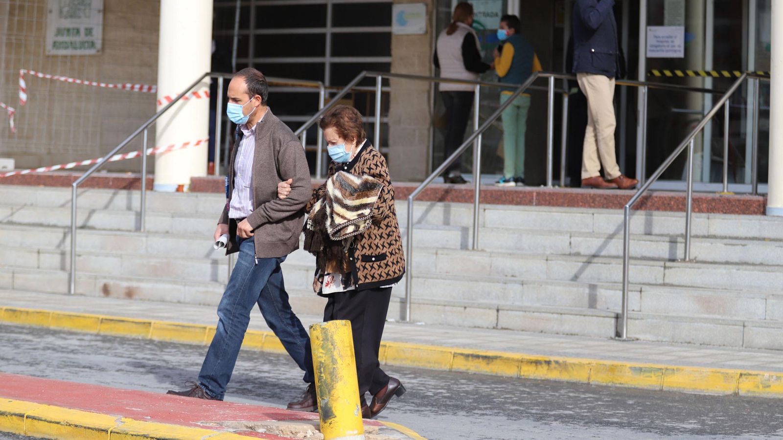 Dos onubenses transitan por las inmediaciones del Hospital Juan Ramón Jiménez.