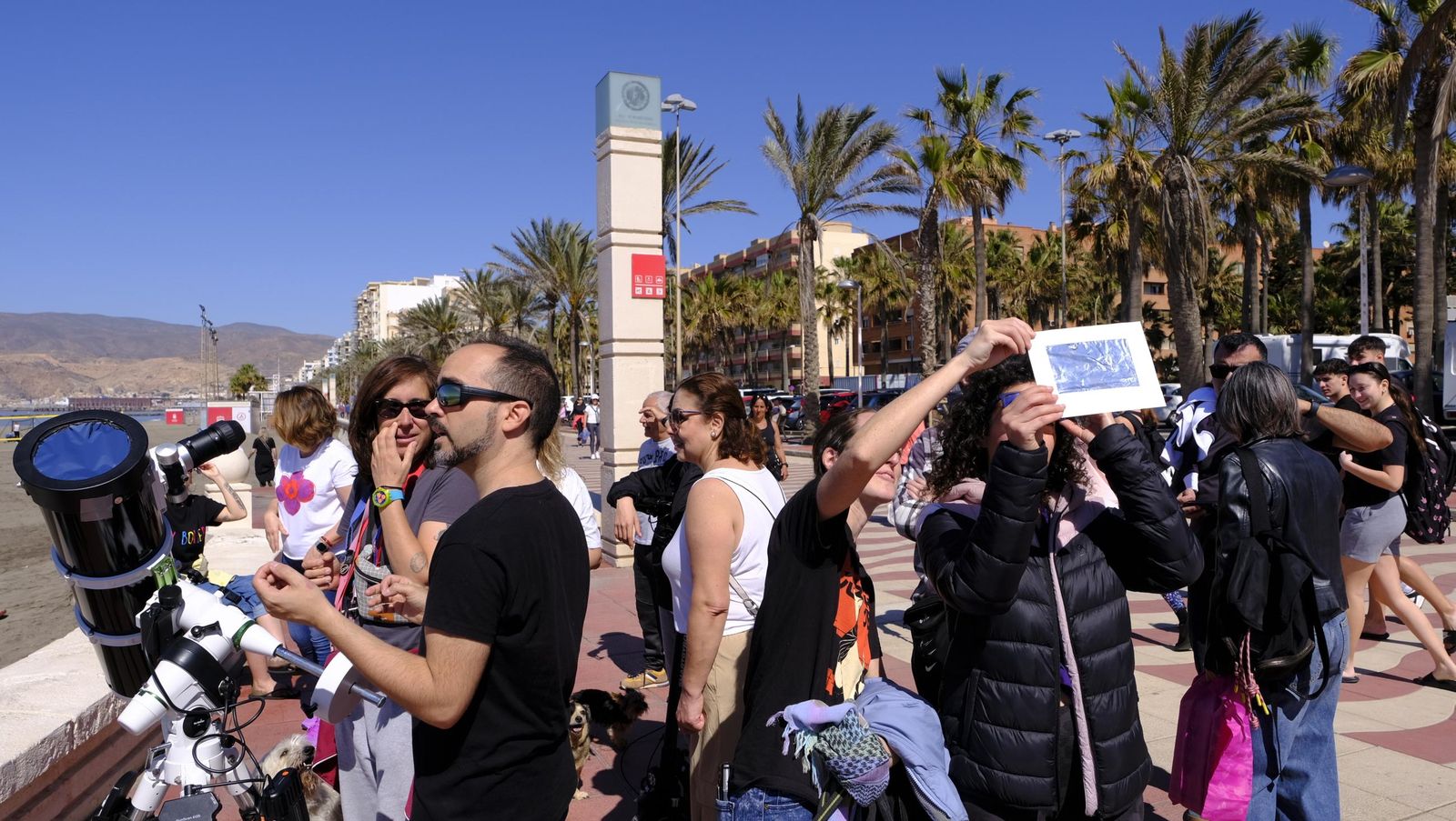 Almería observa el eclipse solar desde el Paseo Marítimo, en imágenes