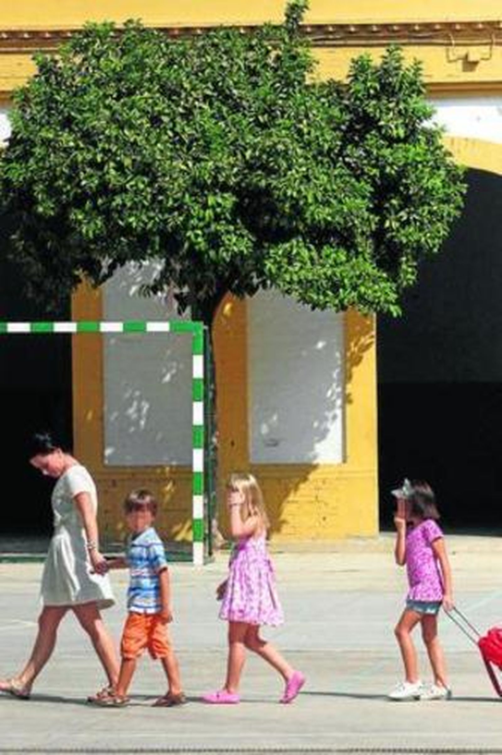 Una madre lleva a sus hijos el primer día al colegio.
