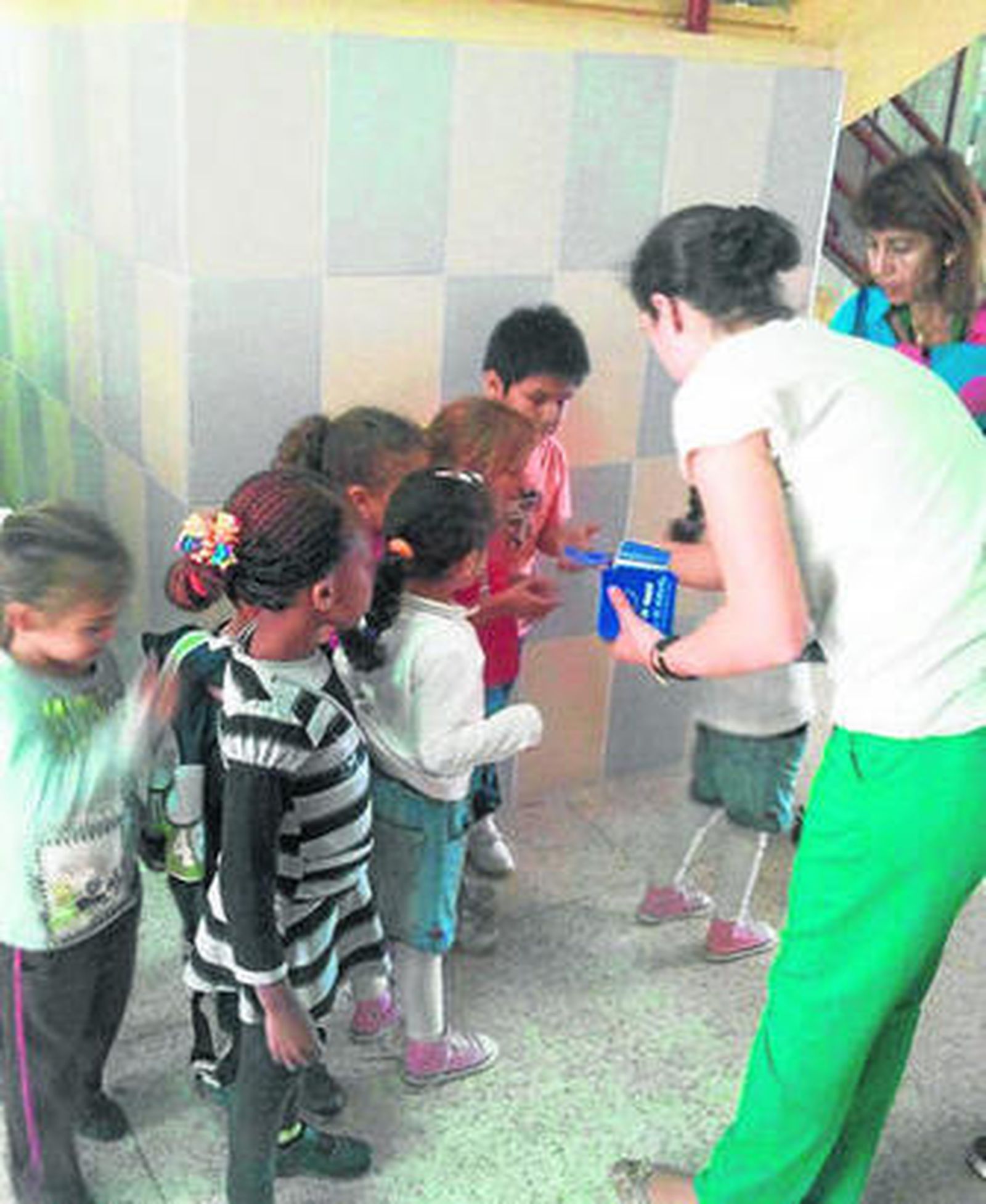 Una profesora reparte material sobre la Unión Europea a los más pequeños.