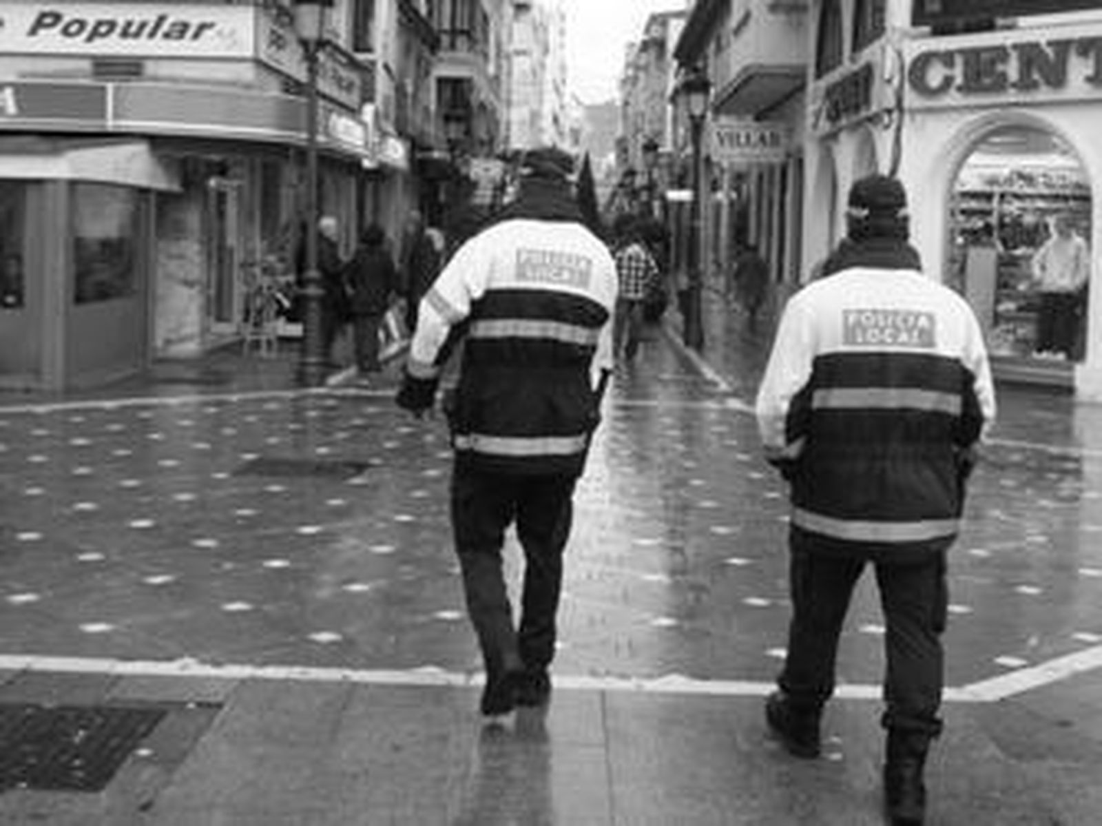 Dos agentes de la Policía Local transitan por la calle Real.