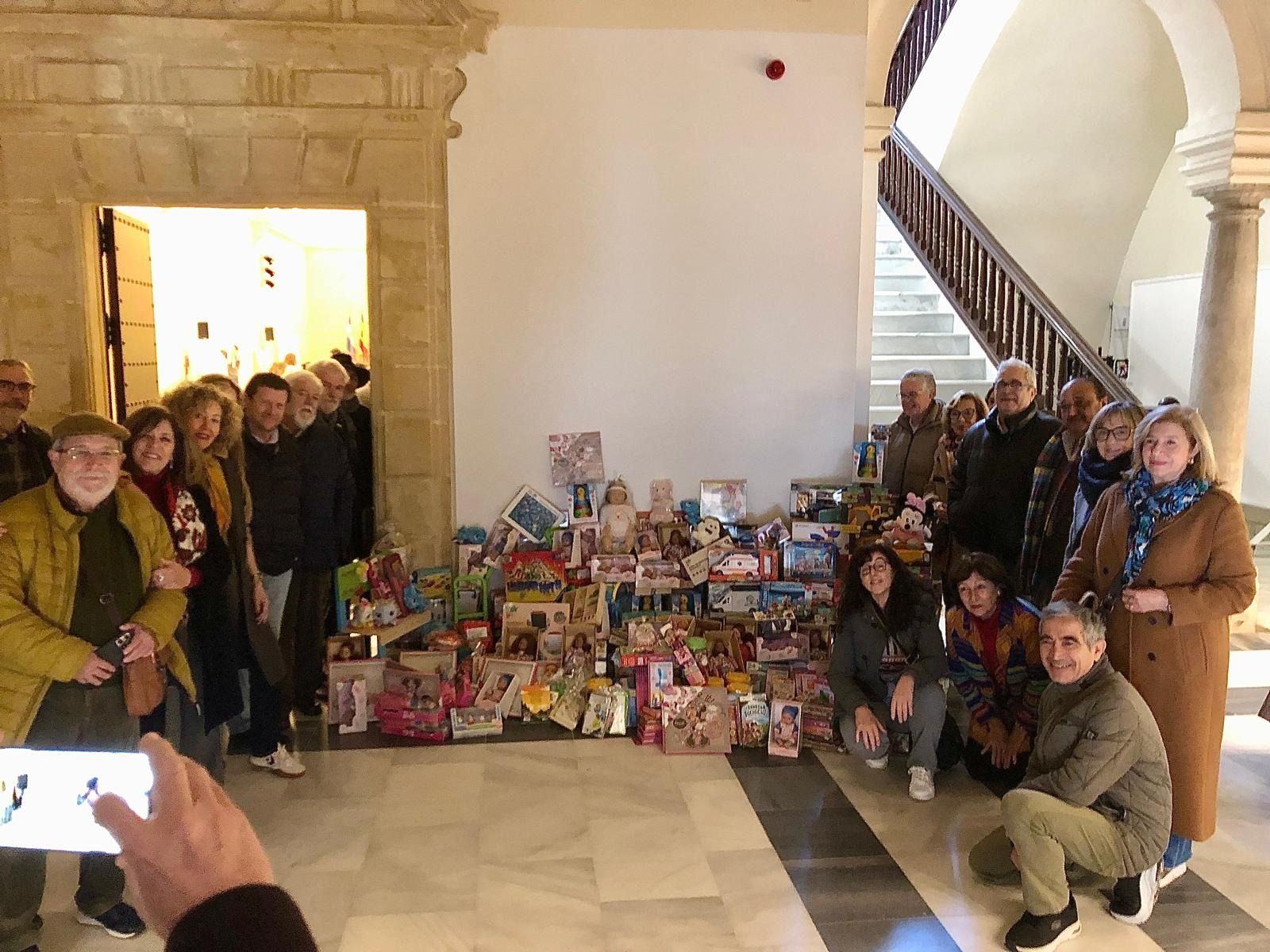 Miembros del Ateneo de Jerez posan con los juguetes donados a los Reyes Magos