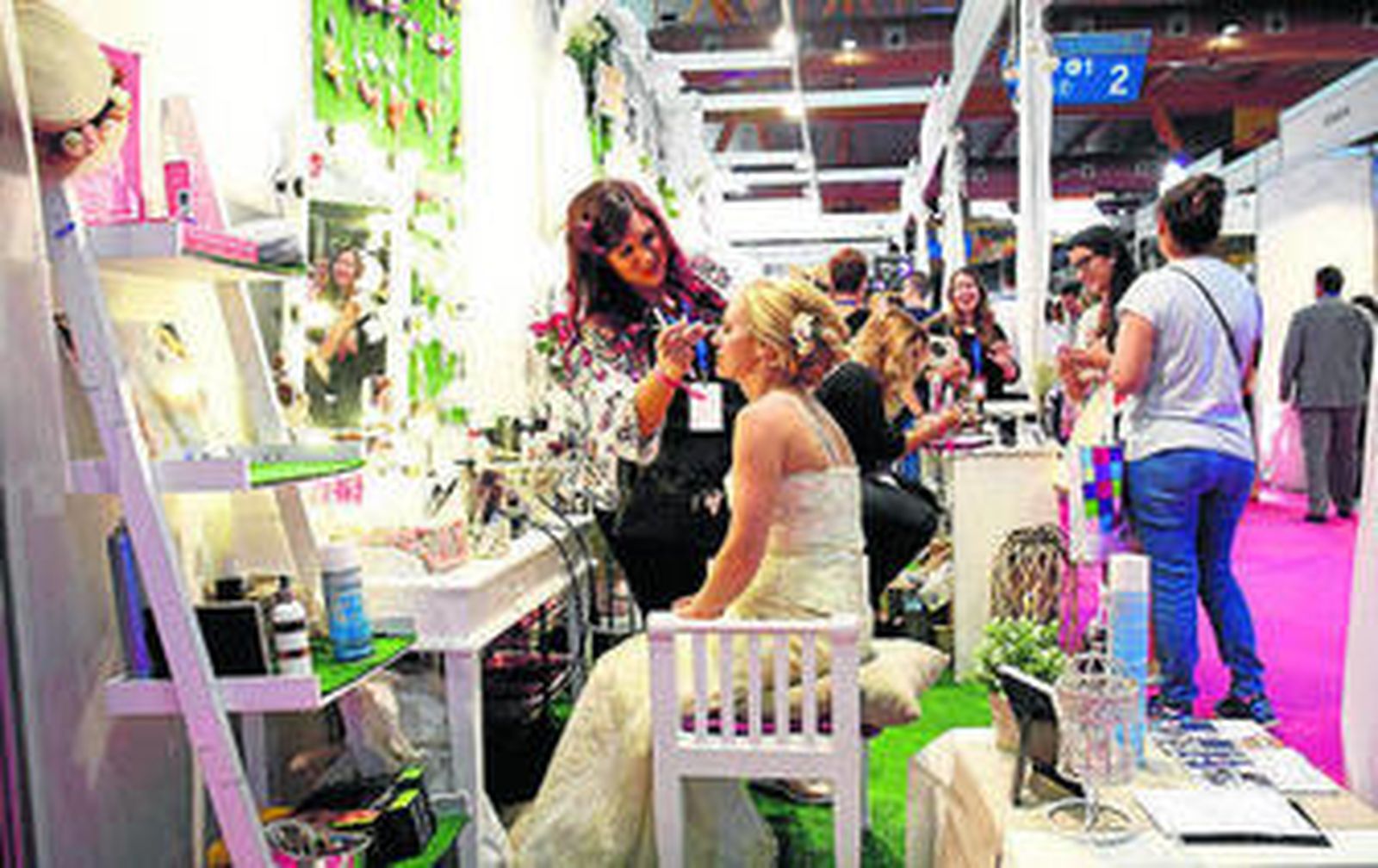 Una estiliasta maquilla a una novia en uno de los expositores de la feria.