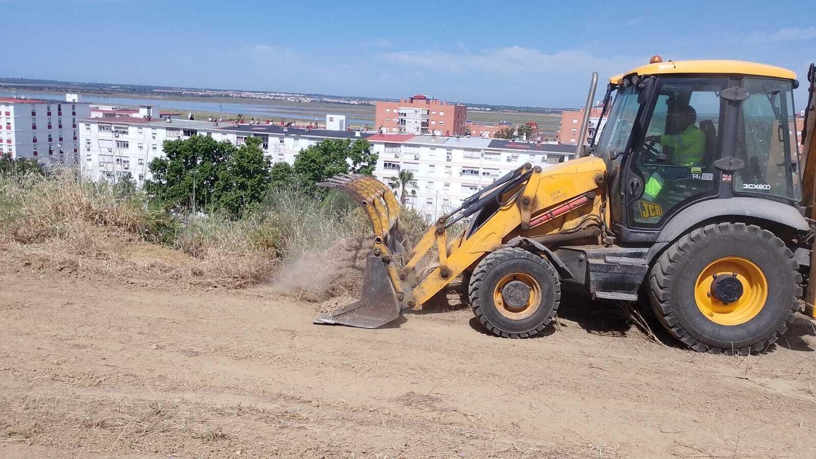 Una excavadora realiza labores de desbroce y saneamiento en el Conquero.