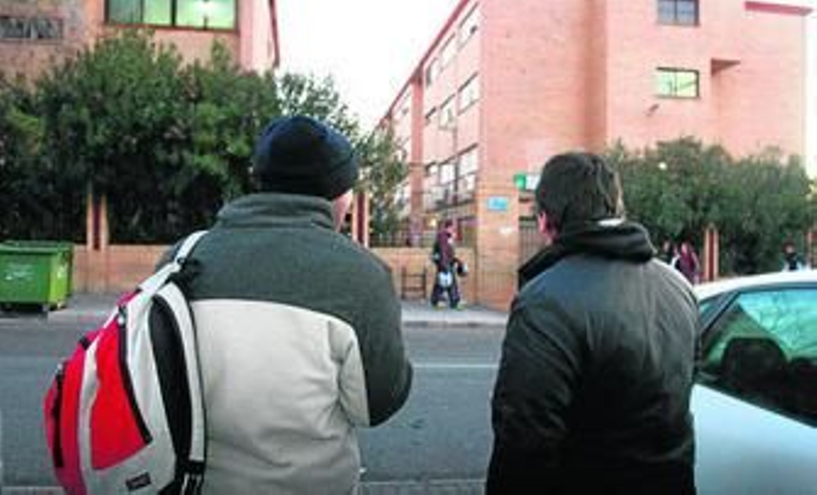 Dos jóvenes estudiantes, ante la puerta de entrada de un instituto onubense de Secundaria.