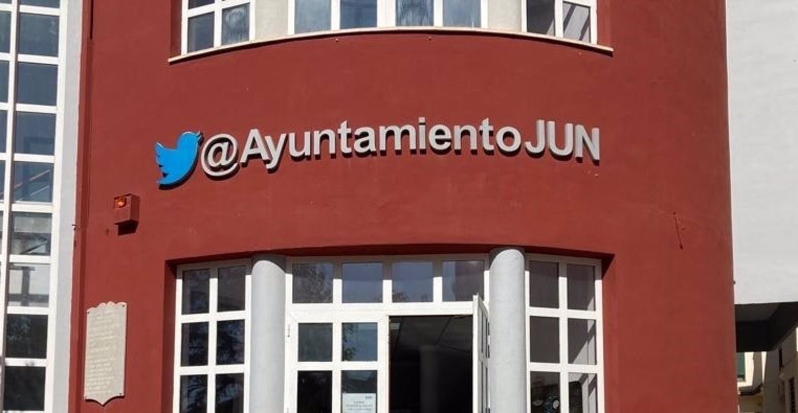 Imagen de la fachada del edificio del Ayuntamiento de Jun con la anterior imagen corporativa de la red social.