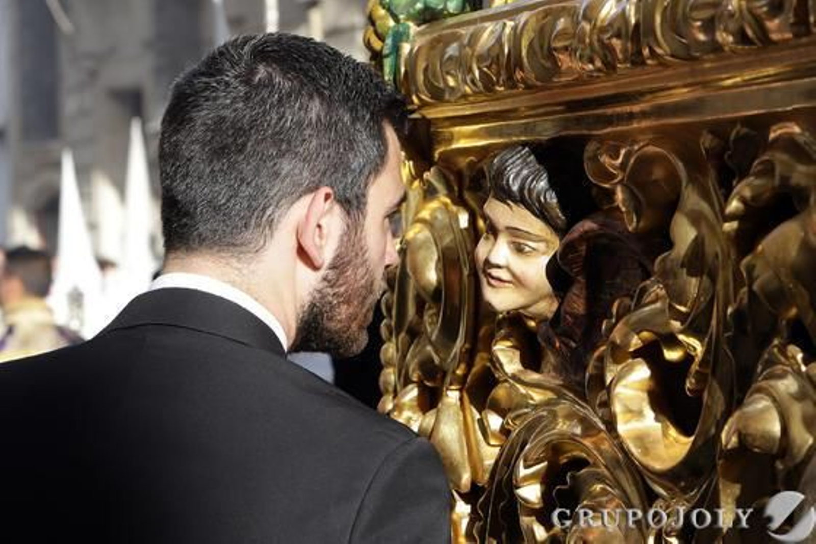 Un miembro del equipo del paso de Jesús del Consuelo parece mirar a uno de los ángeles de la canastilla.

Foto: Manuel Aranda