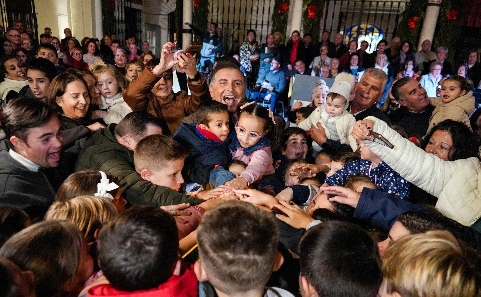El alcalde de Moguer rodeado de niños en el momento de encender el alumbrado.