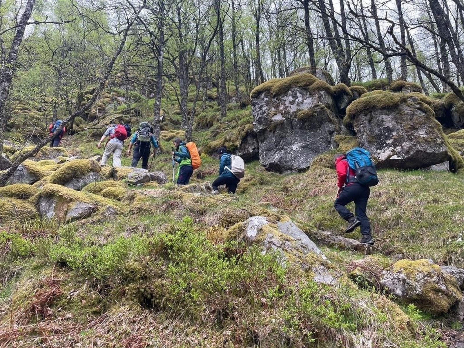 Varias personas realizan senderismo por una zona escarpada