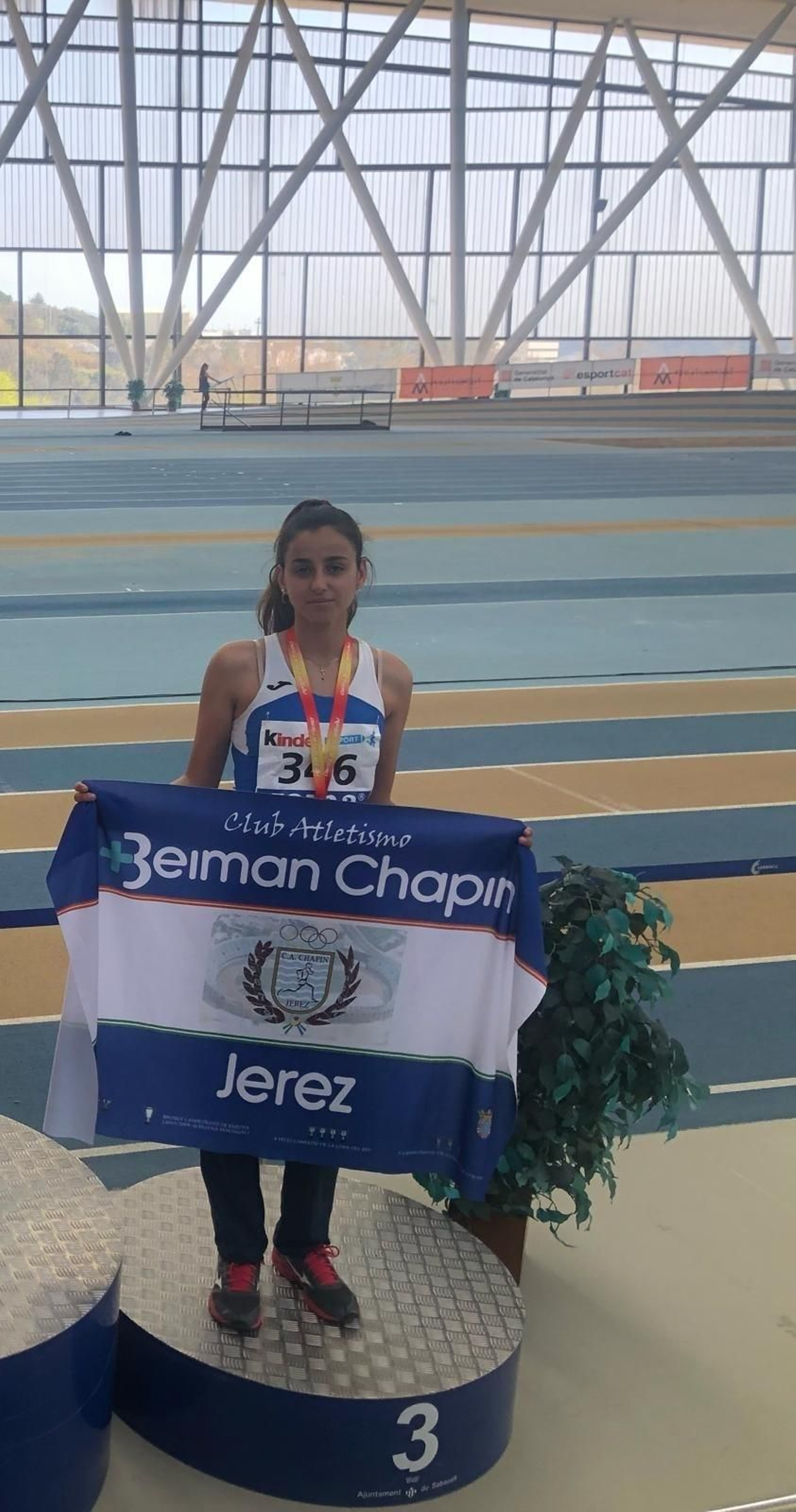 Marta Moreno, en el podio de Sabadell con la bandera del CA Beiman Chapín Jerez.