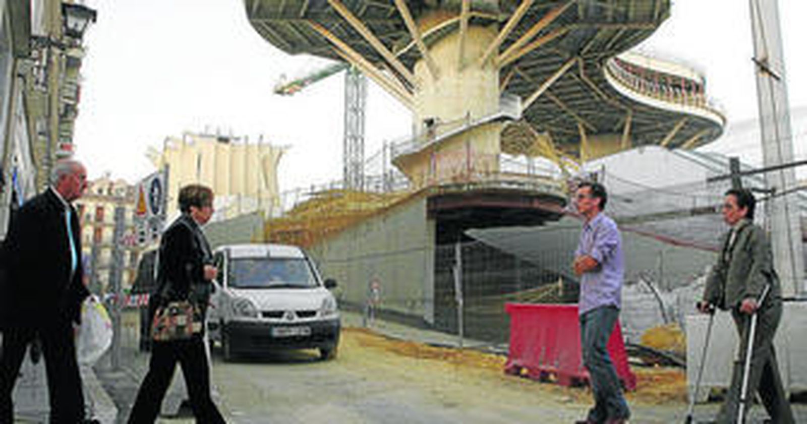 Un vehículo y varios viandantes transitan por la Encarnación.