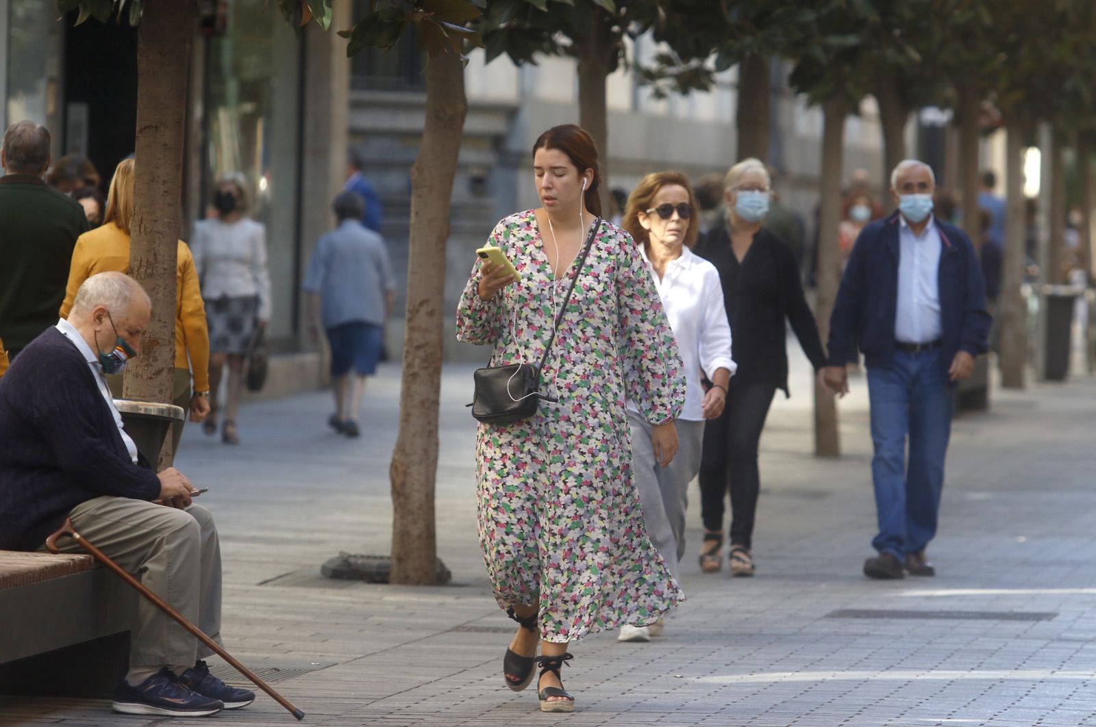 Una joven camina por el centro de Córdoba capital mirando su móvil.