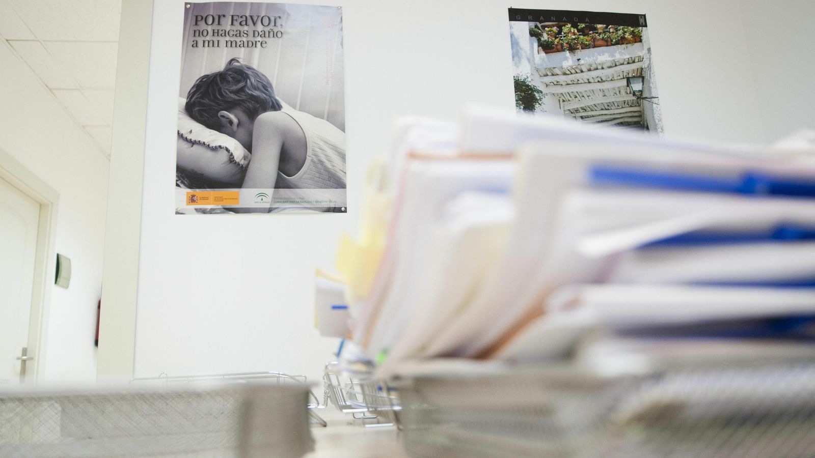 Expedientes y carteles contra la violencia de género en un juzgado.