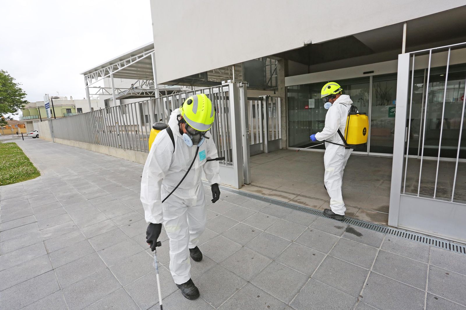 Dos bomberos desinfectan el exterior del centro de salud de La Milagrosa.