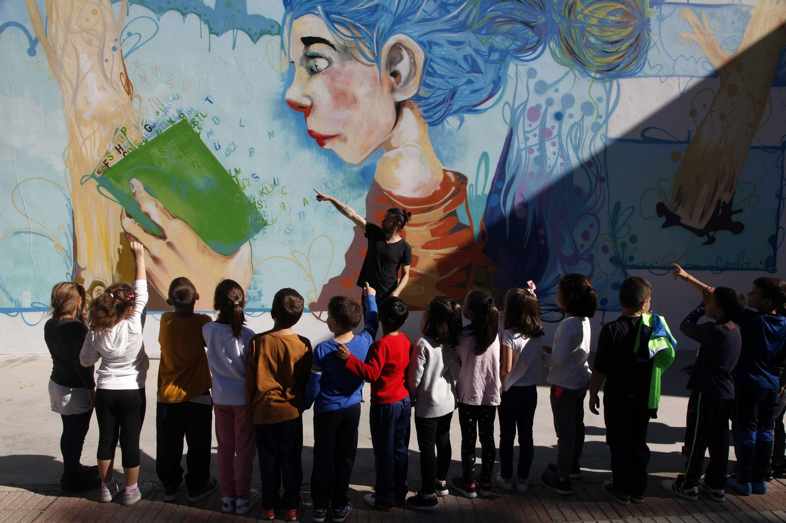 Chencho Aguilera muestra su mural a los alumnos del colegio Moreno Chacón de Ayamonte.