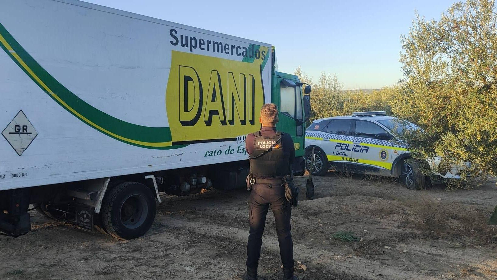 Un agente de la Policía Local de Íllora junto al camión en un olivar