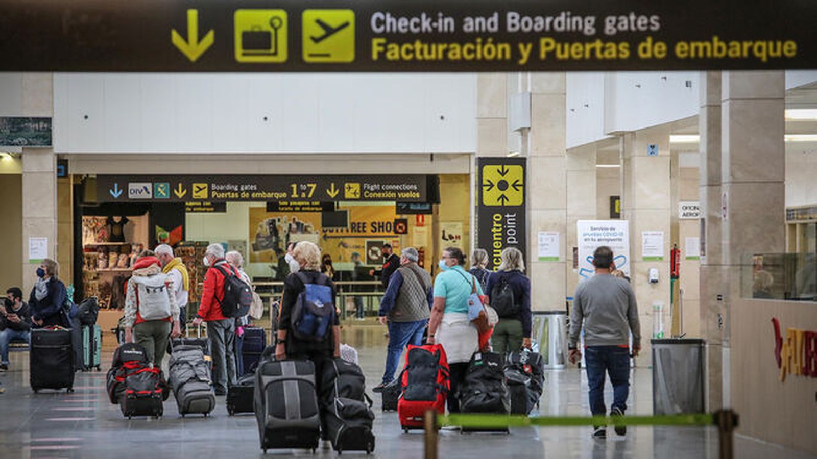 Varios turistas caminan por el interior de un aeropuerto