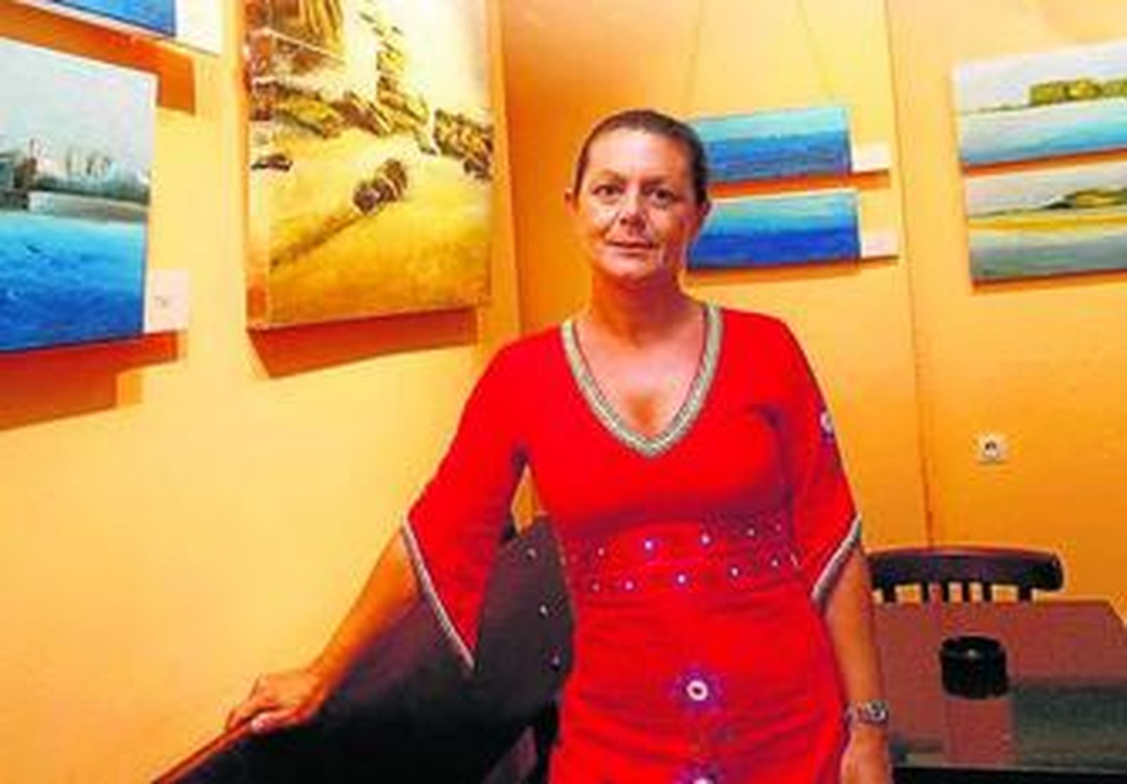 Isabel Vela, junto a algunos de sus cuadros en la exposición.