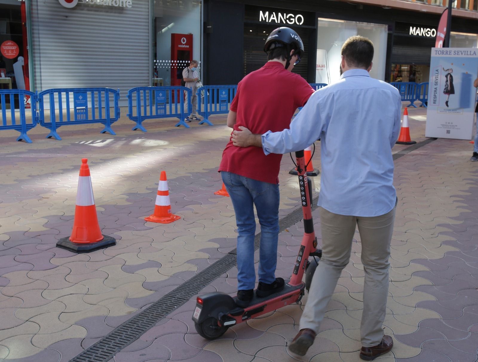 Jóvenes con síndrome de Down aprenden a montar en patinete eléctrico en Torre Sevilla.