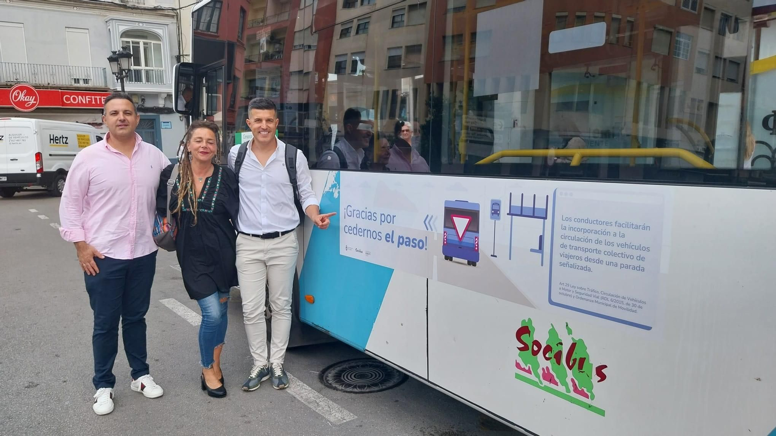 La concejal, Raquel Ñeco junto a varios técnicos muestra las nuevas pegatinas de un autobús urbano.
