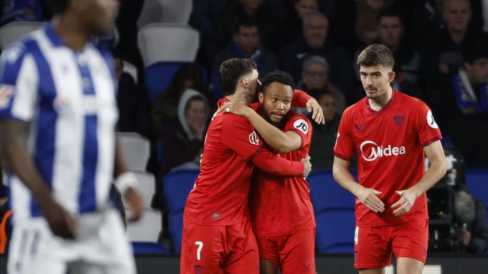 Isaac abraza a Ejuke tras marcar éste ante la Real Sociedad en presencia de Kike Salas.