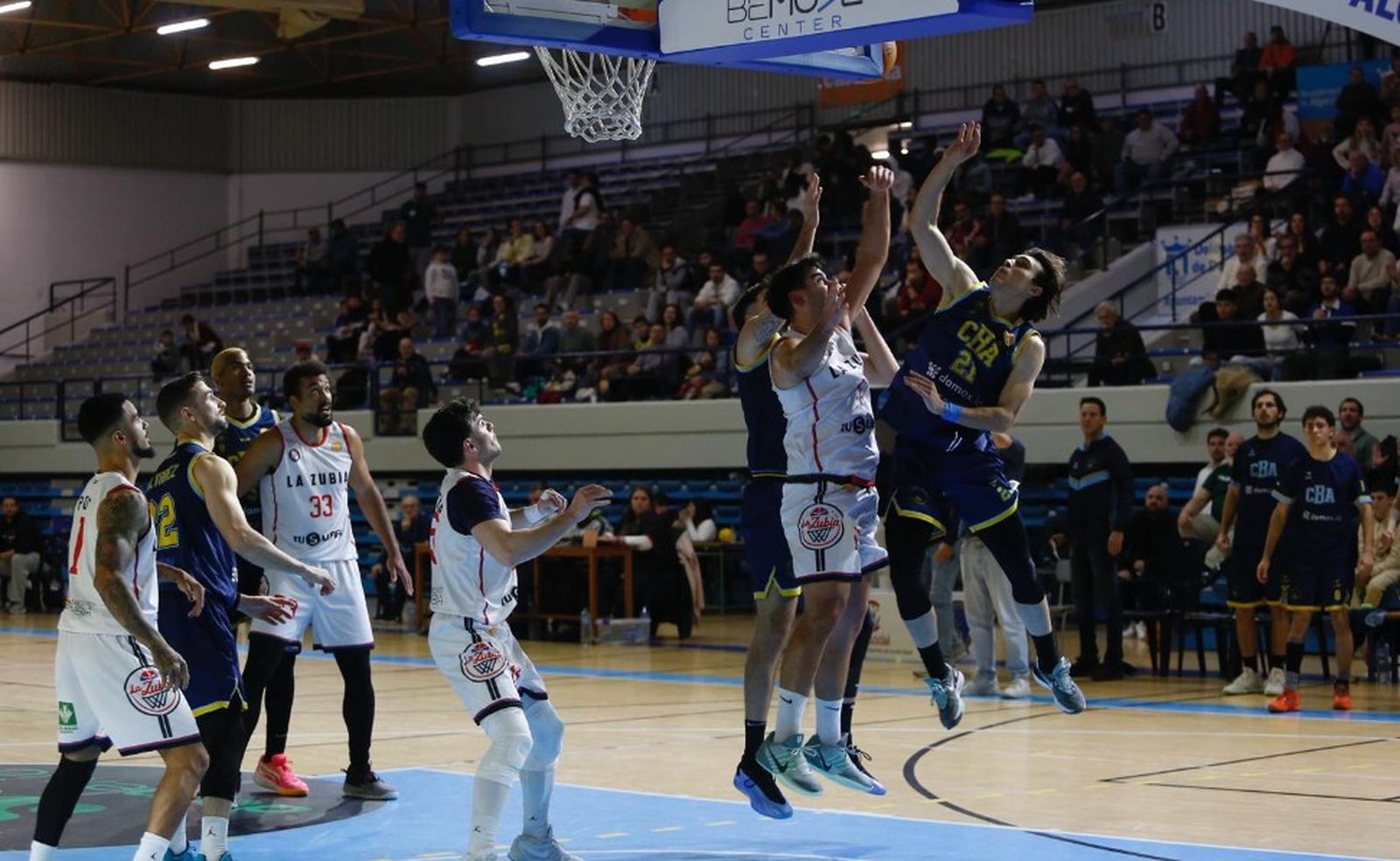 Jugadores de los dos equipos pelean por un rebote