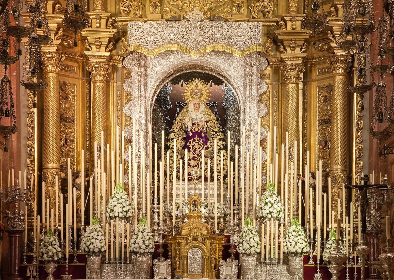 Una montaña de velas envuelve a la Esperanza Macarena para su septenario.