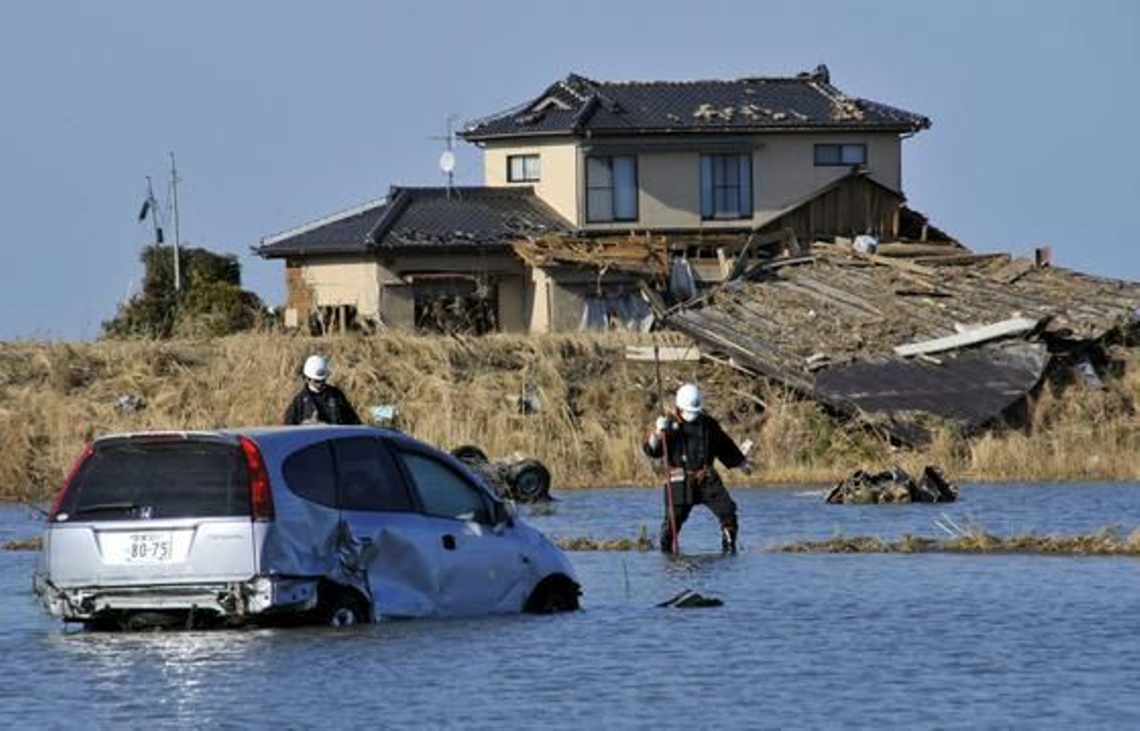 Equipos de rescate buscan víctimas en el agua en Yamamoto, al sur de Sendai, en la región de Miyagi (Japón) tras la devastación del tsunami.