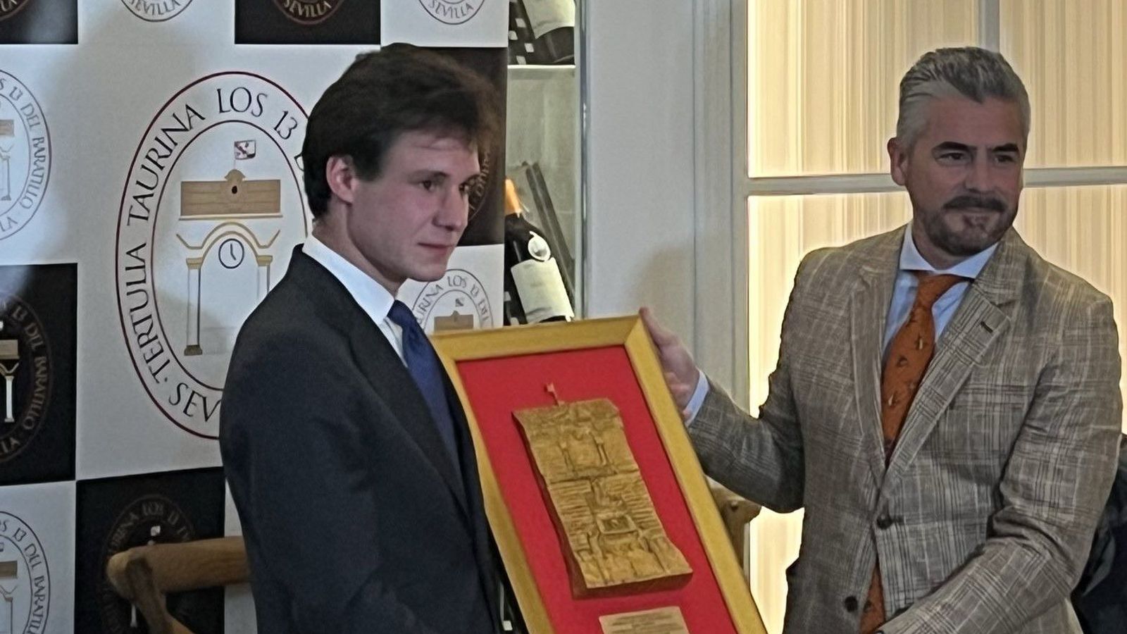 Fabio Jiménez recibe el trofeo de manos de Carlos Trejo, presidente de la tertulia Los 13.