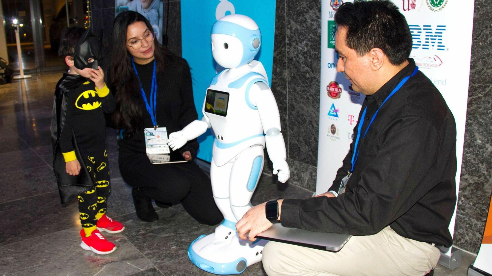 Nick interactúa con un niño vestido de Batman.