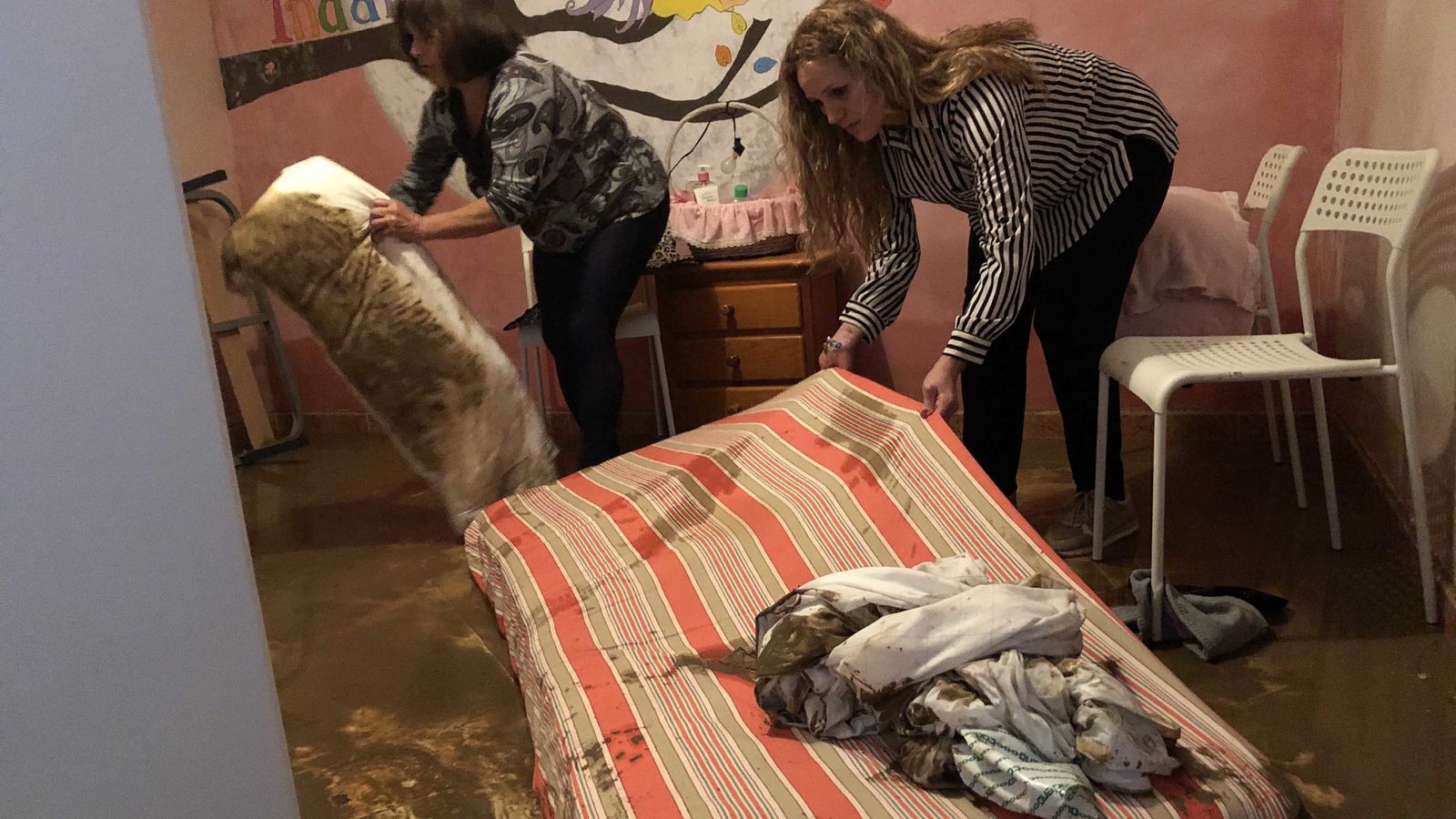 Mujeres limpian el interior de una vivienda.