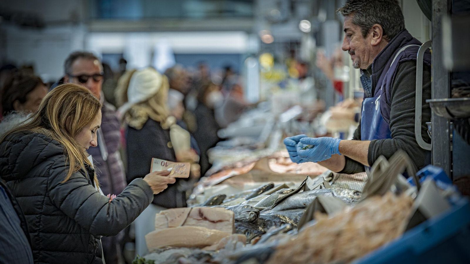 Una mujer compra pescado en un puesto del Mercado de Abastos de Cádiz.
