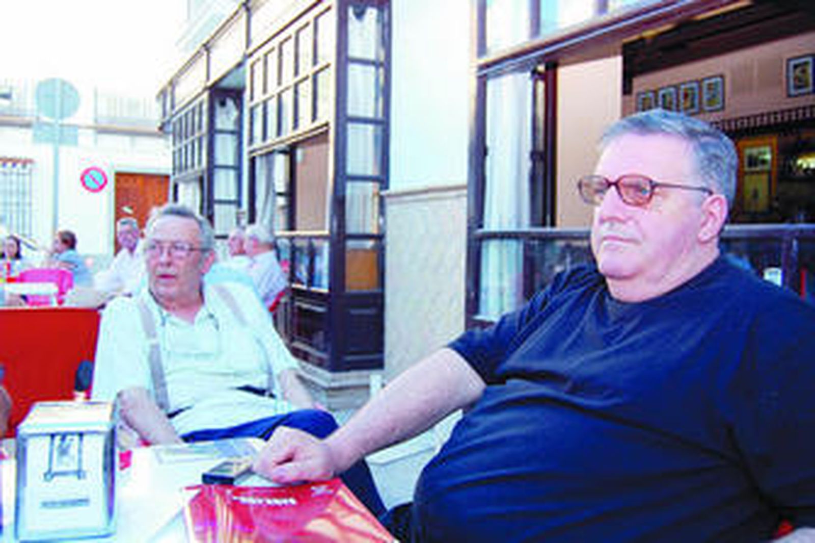 En primer término, Pepe el Cachas con Fernando el del Central sentados en la plaza del cabildo.