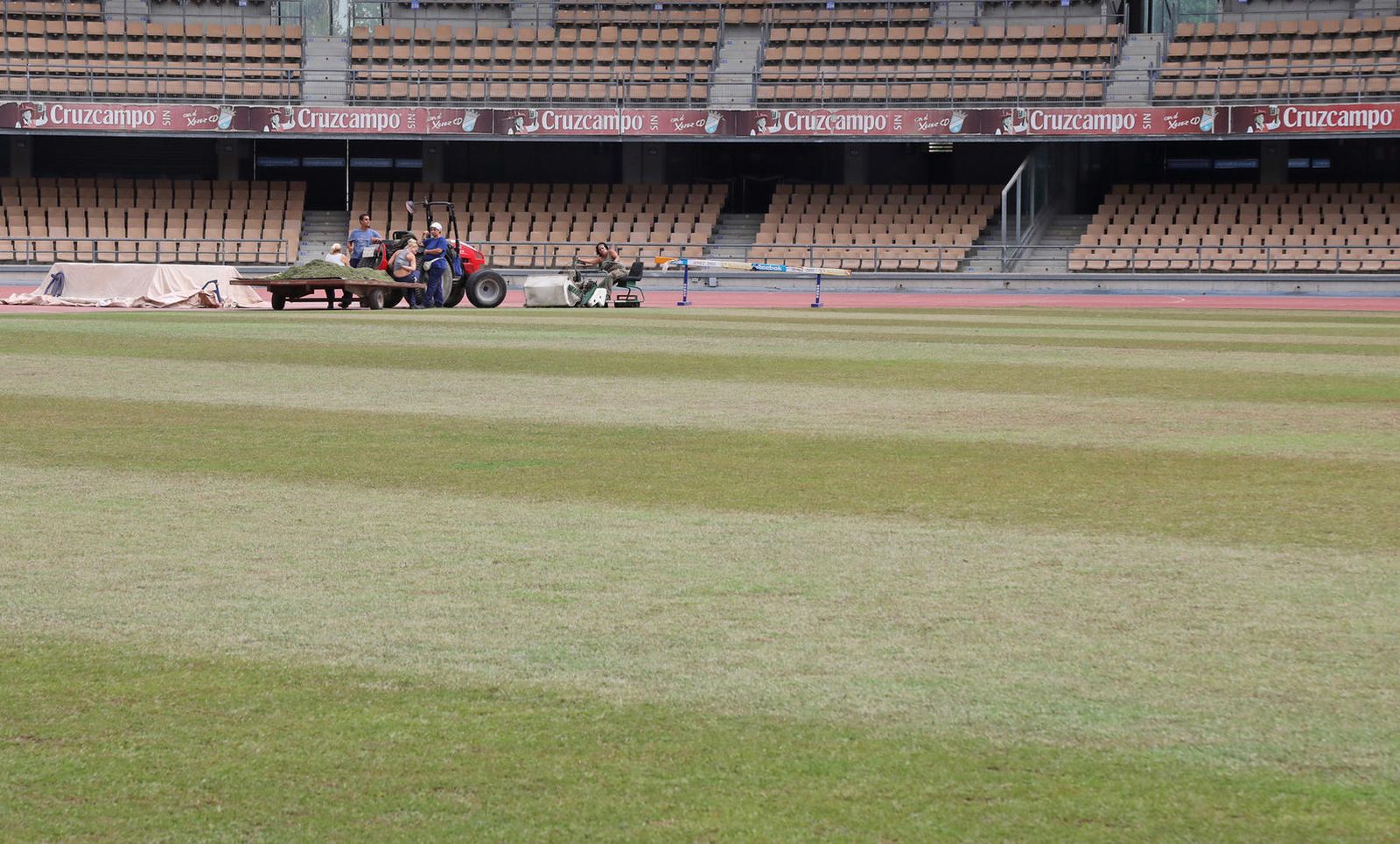 Operarios municipales, en plena faena con el césped del estadio Chapín.