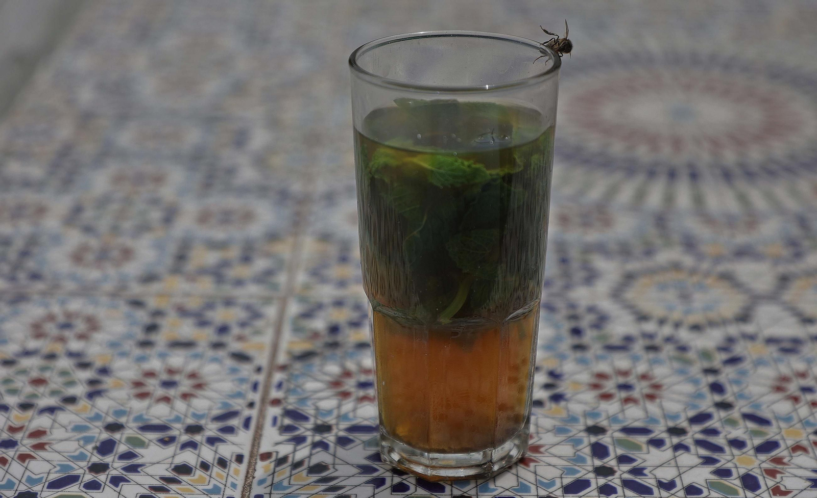 Alguien sirve té con hierbabuena en vasos altos que escaldan los dedos.