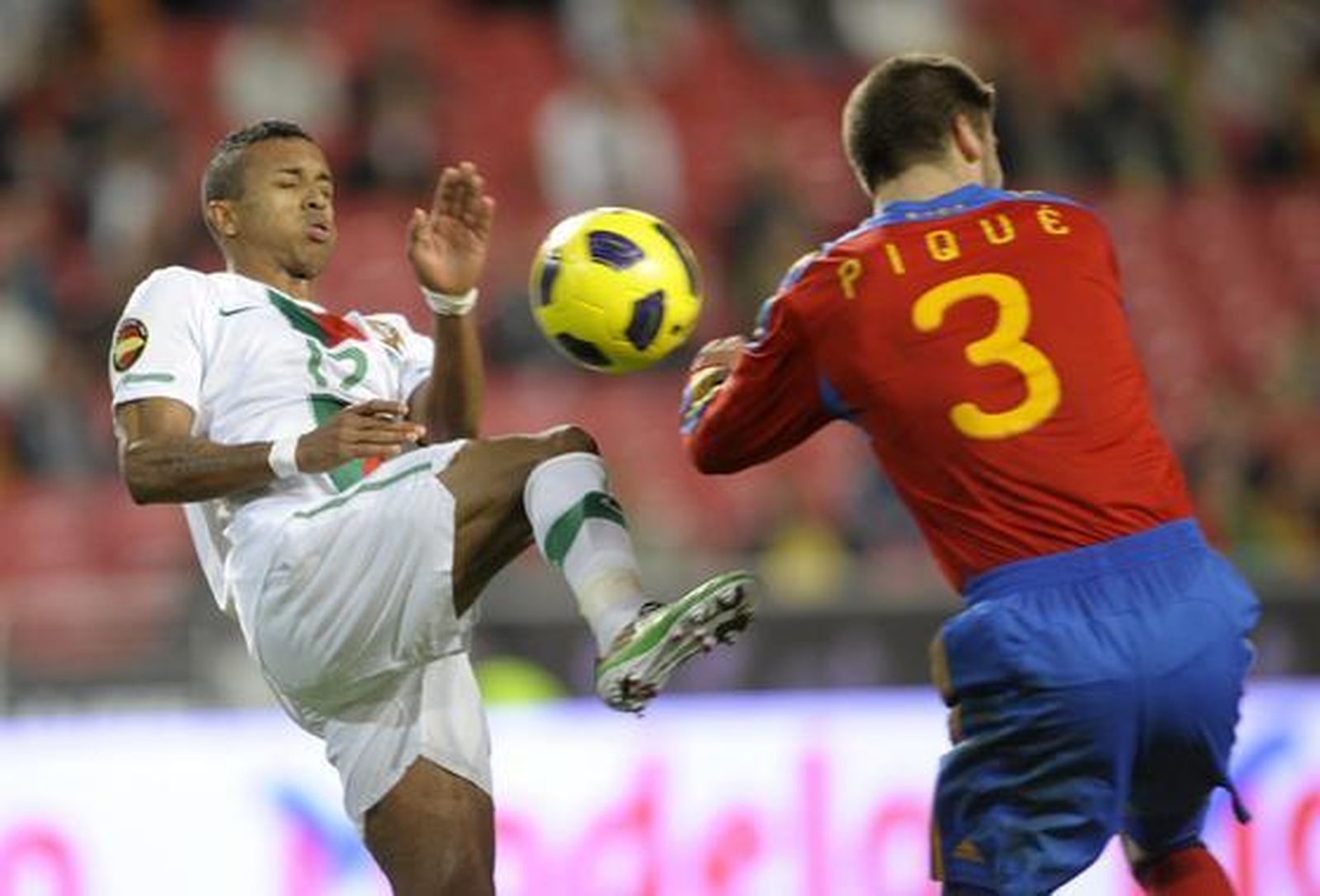 Piqué salta con Nani por una pelota. / AFP