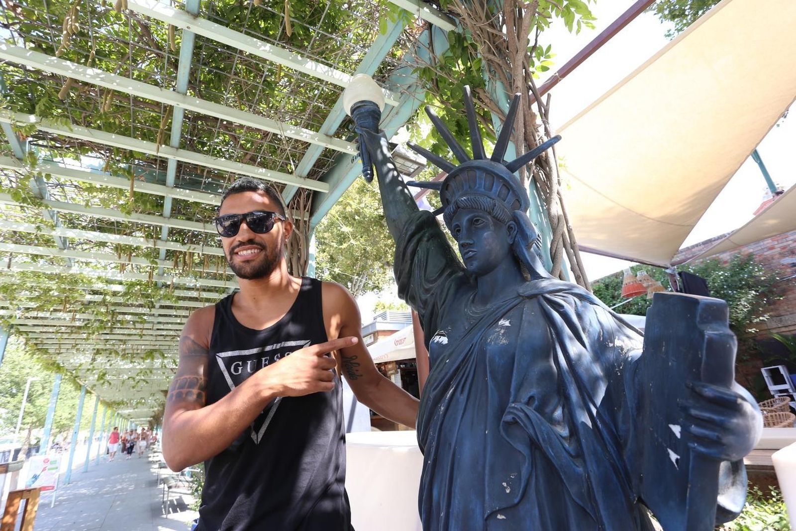 Lucas Moure, junto a la estatua de la Libertad del bar New York donde trabaja.