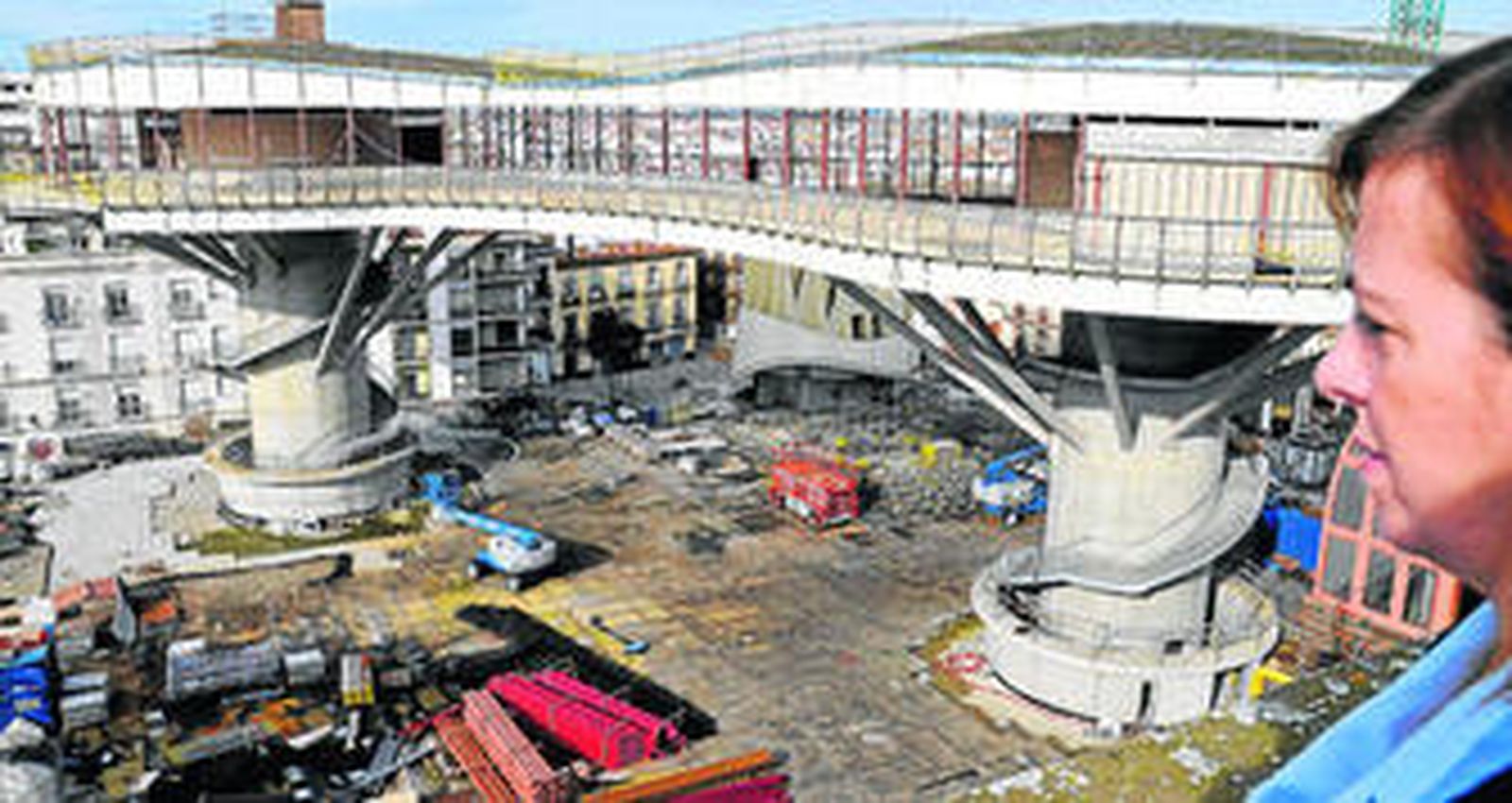 Una vecina mira desde lo alto el esqueleto del futuro restaurante-mirador que tendrá la plaza sobre los parasoles centrales, pendientes de la cubierta de madera.