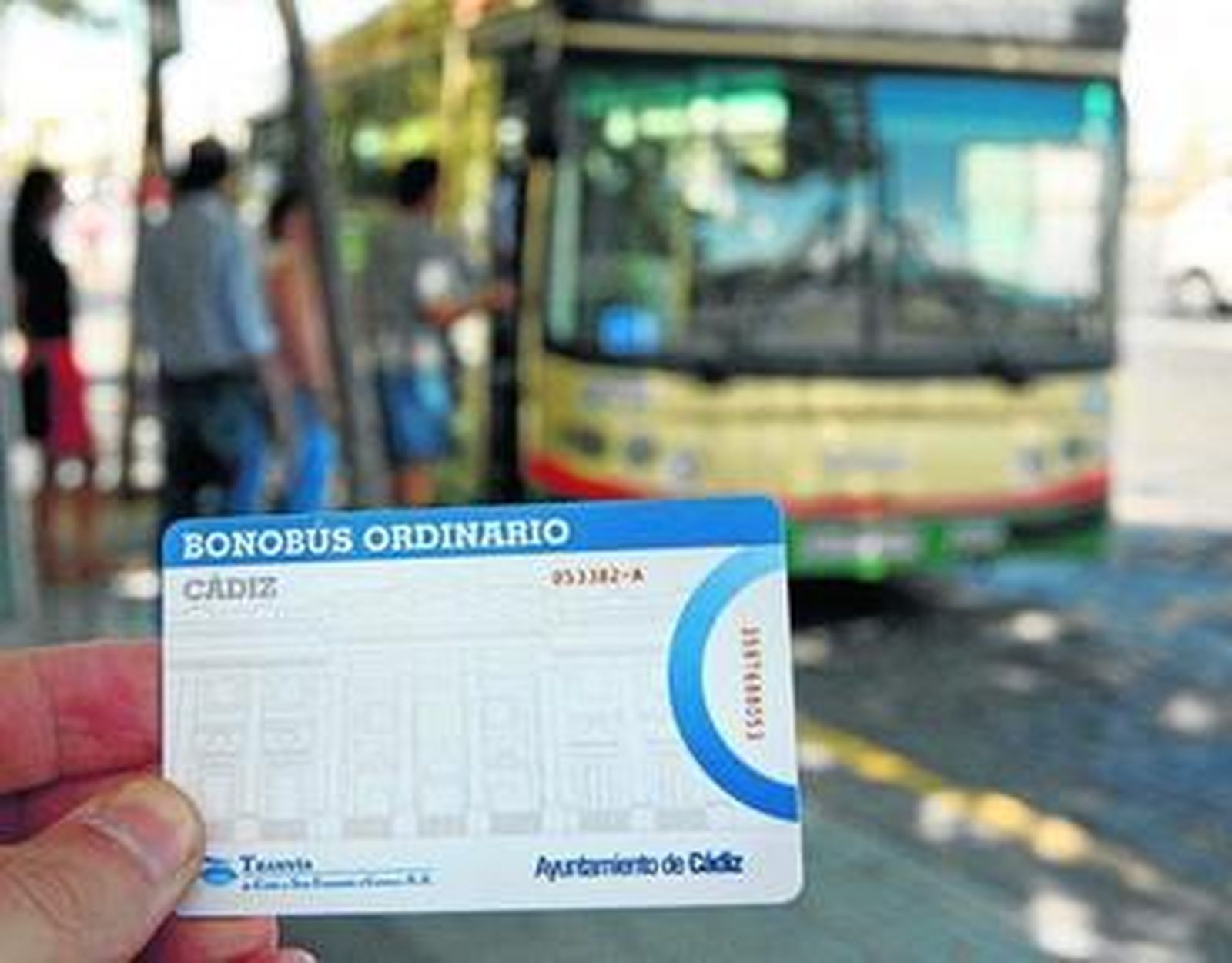 Una tarjeta de transporte sin contacto, ante un autobús del servicio municipal de transportes.
