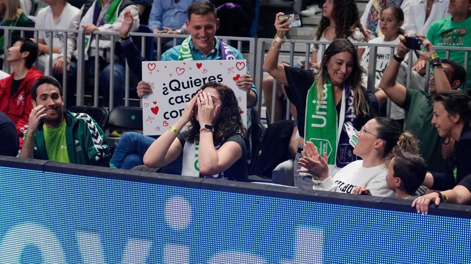 Guille muestra el cartel de pedida ante una sorprendida Alicia. Guille muestra el cartel de pedida ante una sorprendida Alicia.