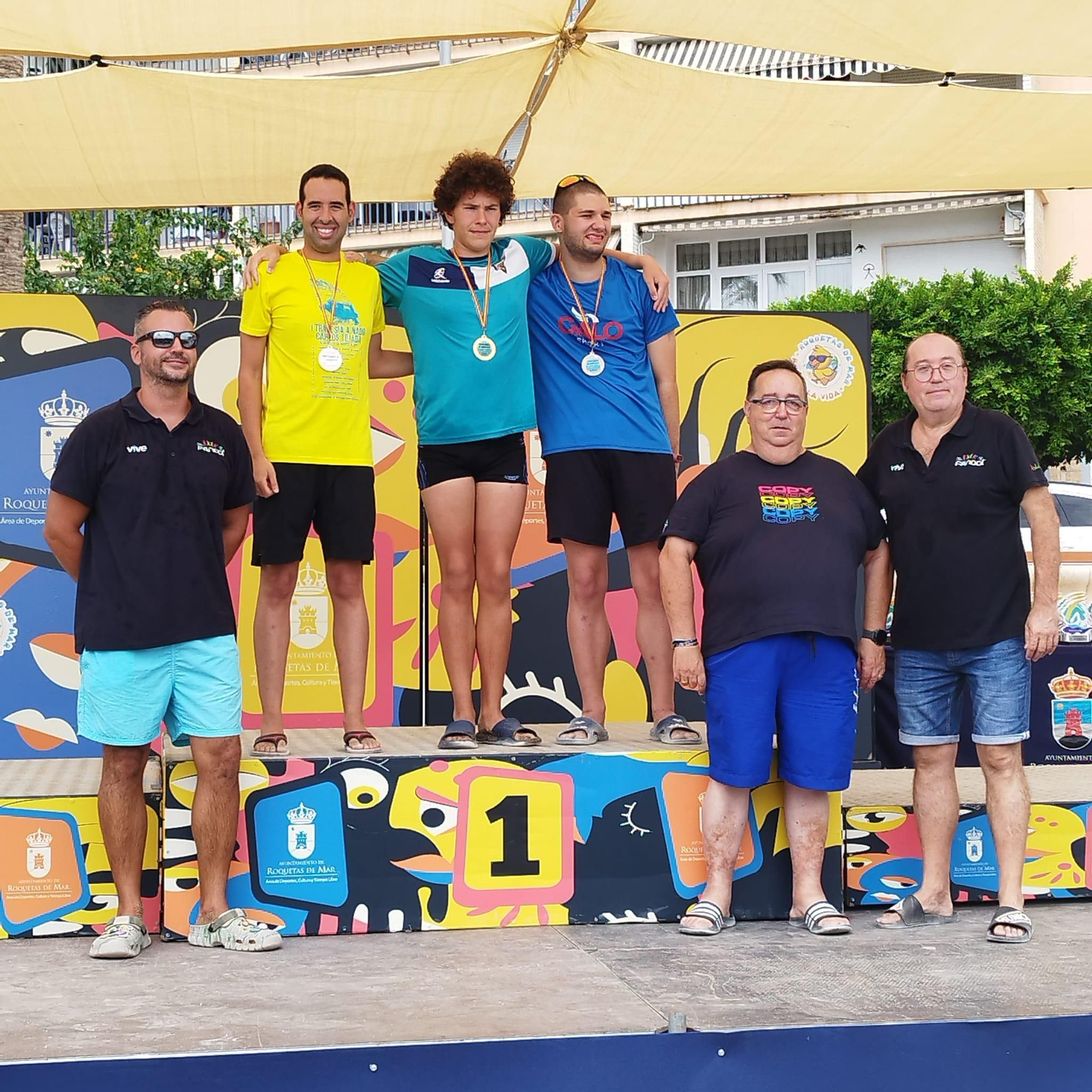 Podio de la Travesía de los Puertos de Roquetas de Mar con el nadador almeriense Carlos Tejada subido al segundo cajón.
